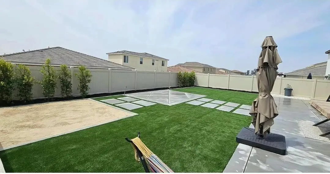Backyard artificial turf installation with large concrete stepping pads