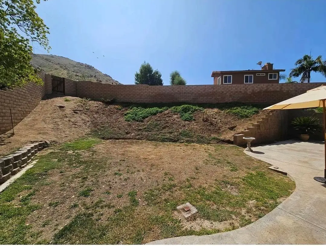 Sloped backyard before retaining-wall construction
